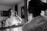 Bride watching her hairstyle and makeup for her wedding in the mirror