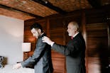 Father helping his son to dress for his wedding