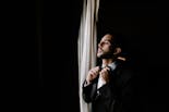 Groom peeking out the window at his wedding
