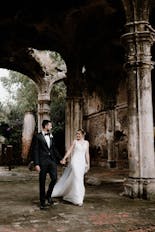 Groom and bride walking holding hands and smiling