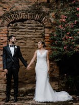 Groom and bride holding hands and looking
