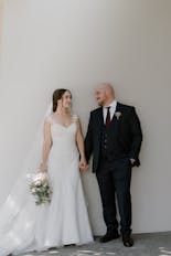 The bride peeking out the window of her room on her wedding day