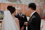 Groom peeking out the window at his wedding
